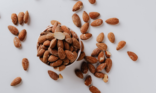 A bowl of almonds is kept on a table.